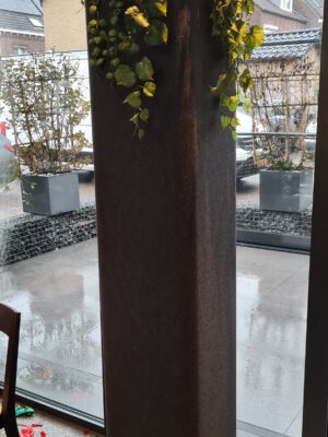 Akoestische Zuil Zwart met Plant in de serre van een woning